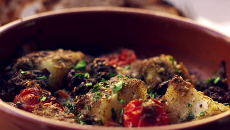 cod and chorizo bake in earthenware dish, close up rack focus