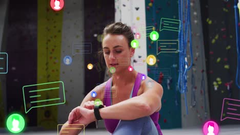 animación de iconos de los medios sobre mujer caucásica con reloj inteligente en la pared de escalada