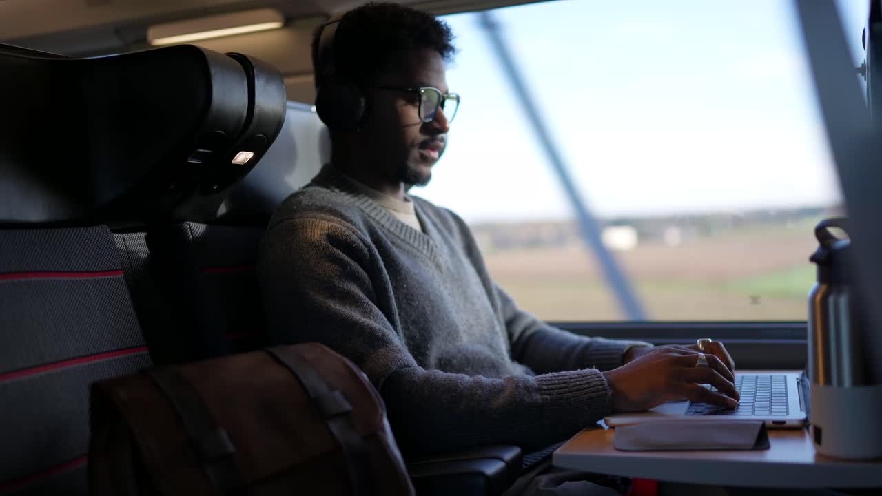 Man working on laptop while traveling by train