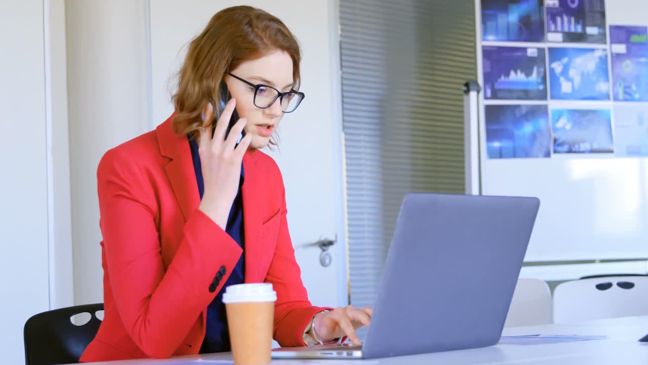 Giovane donna d'affari caucasica che parla al cellulare in un ufficio moderno 4k