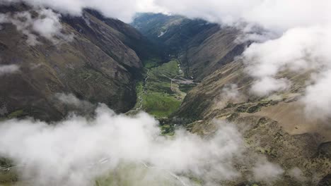Drone-shot-of-clouds-and-a-green-valley-in-the-mountains-of-Cusco