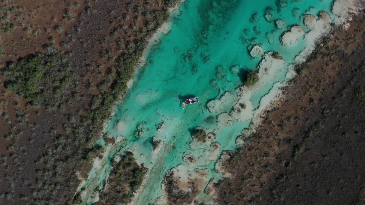 Ripresa aerea discendente rotante di una barca in acque tropicali in Messico, Sud America