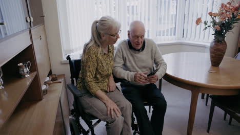 elderly couple using mobile phone at home