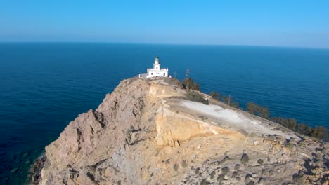Racing-FPV-drone-on-the-legendary-lighthouse-of-Santorini,-Greece