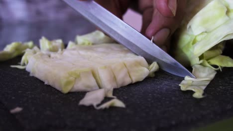 joven cortando repollo para ensalada