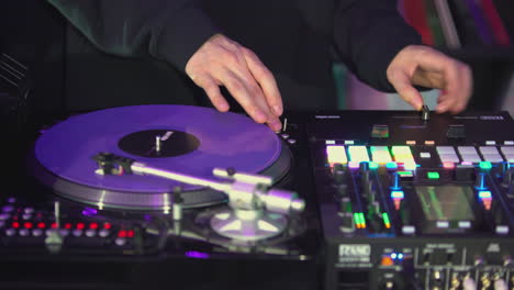 dj mixing music on turntable and mixer