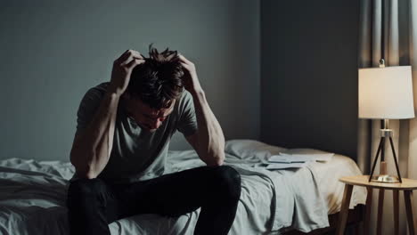 depressed man sitting on bed