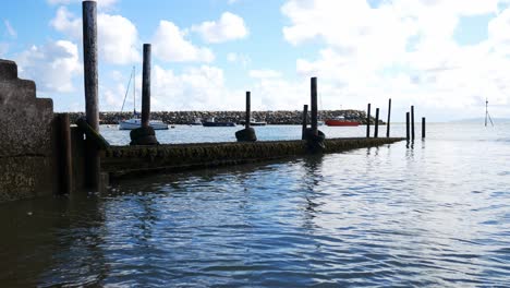 weathered wooden harbour dock walkway on sunny conwy north wales peaceful sea tide