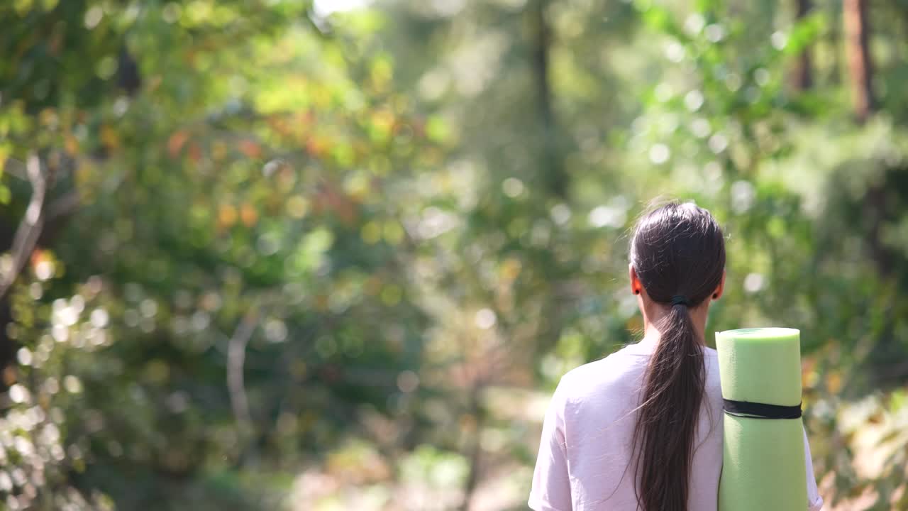 숲에서 요가 매트를 가진 소녀