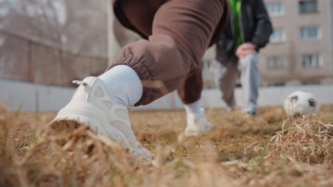 도심을 배경으로 스트레칭하는 선수의 클로즈업, 거친 도시를 배경으로 돌진하는 선수의 액션 사진, 도시 놀이터 대회에서 빠르게 몸을 푸는 운동선수의 생생한 장면