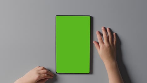 Overhead-Close-Up-Studio-Shot-Of-Child-Using-Green-Screen-Digital-Tablet-1