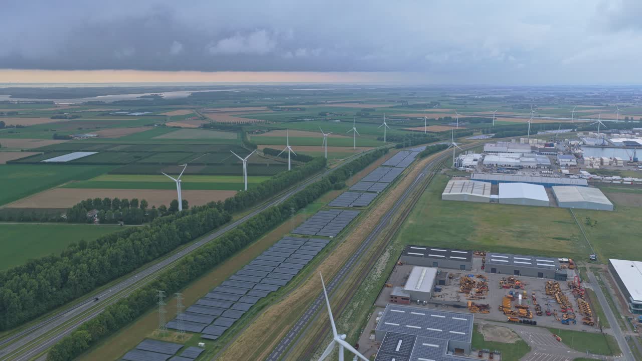 Aerial drone of industrial zone with solar panels and wind turbines, Netherlands