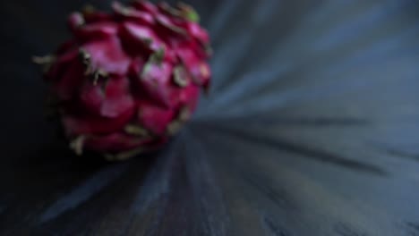 La-Mano-Del-Hombre-Colocando-Una-Fruta-De-Dragón-Rojo-Sobre-La-Mesa-Rodajas-De-Fruta-Y-Cultivando-Plantas-Exóticas-Pitaya.