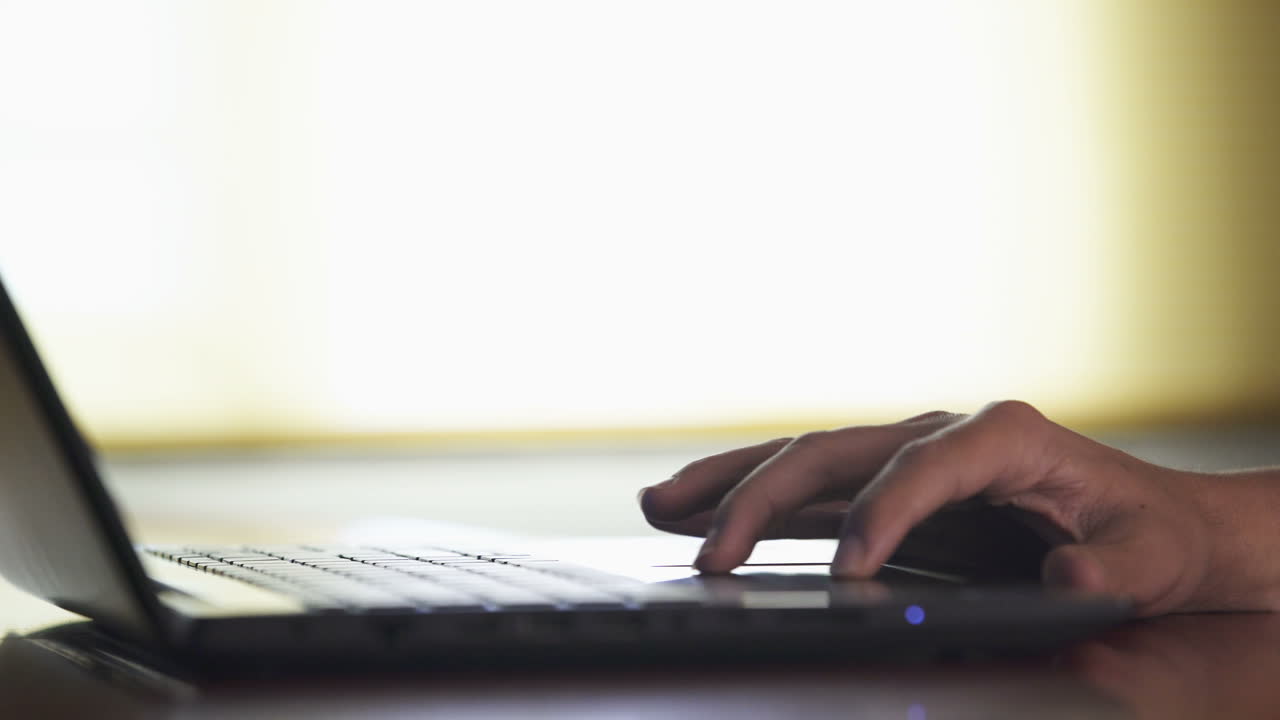 Hand typing on a laptop