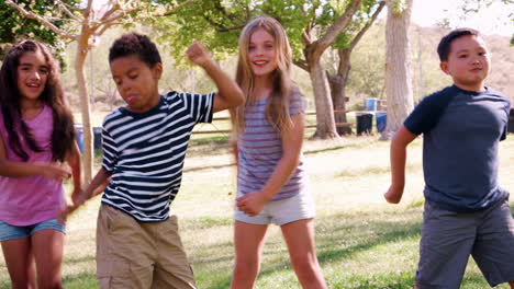 grupo de niños con amigos en el parque bailando y usando el hilo dental