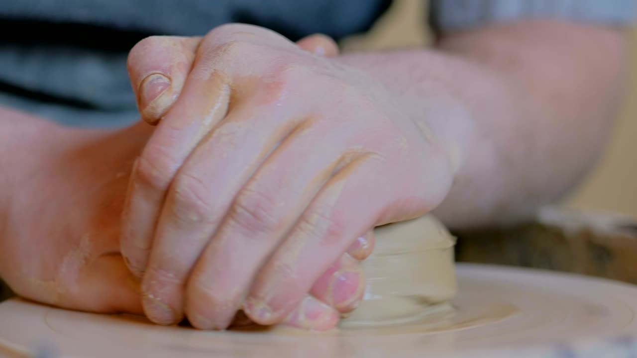 un alfarero profesional que trabaja con arcilla en la rueda del alfarero