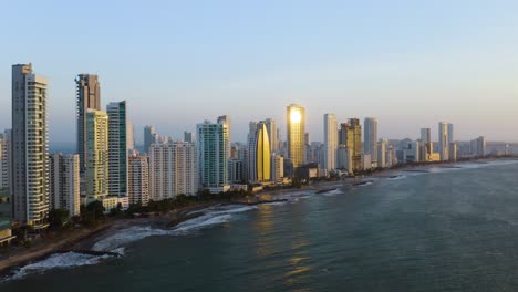 aerial establishing shot of beaches and modern skyscrapers at sunset in cartagena, bolivar, colombia