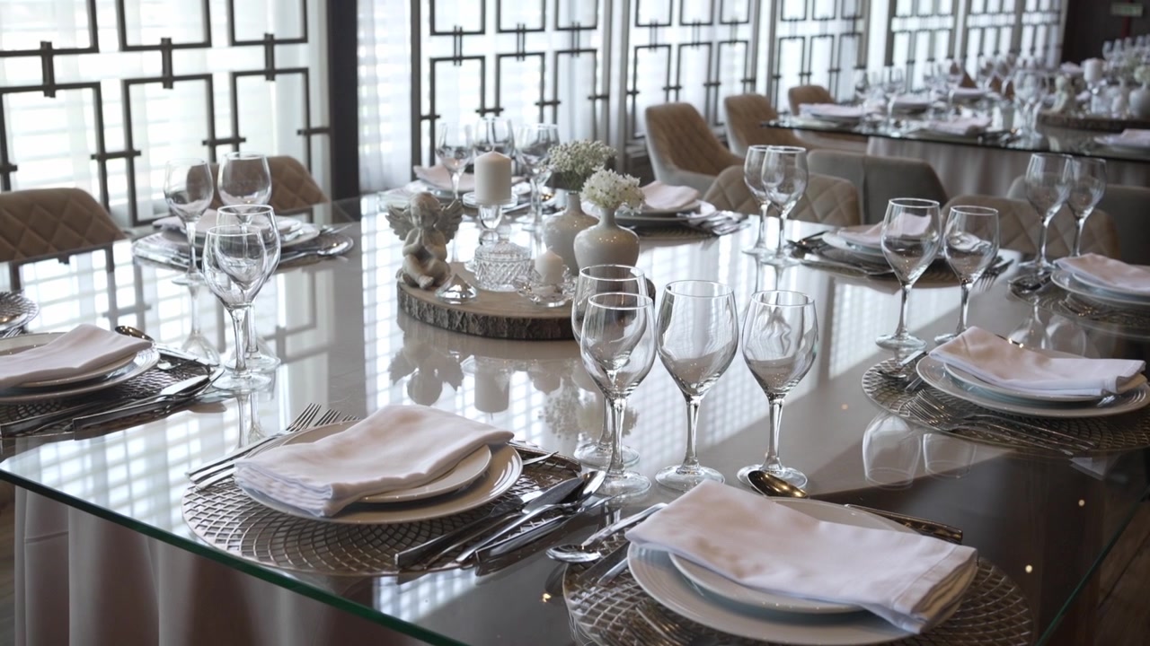 Elegant banquet setup with glass tables and fine dining décor in a modern interior