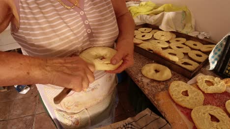 cutting bread with the knife to make freselle, typical southern italian hard bread