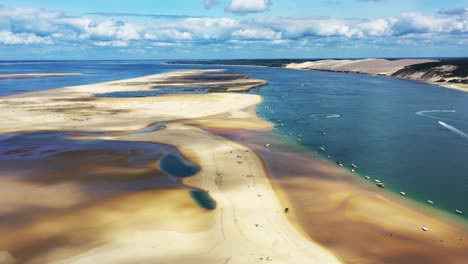 arcachon bassin france over banc d'arguin with boats anchored on the south passage, aerial dolly out reveal shot