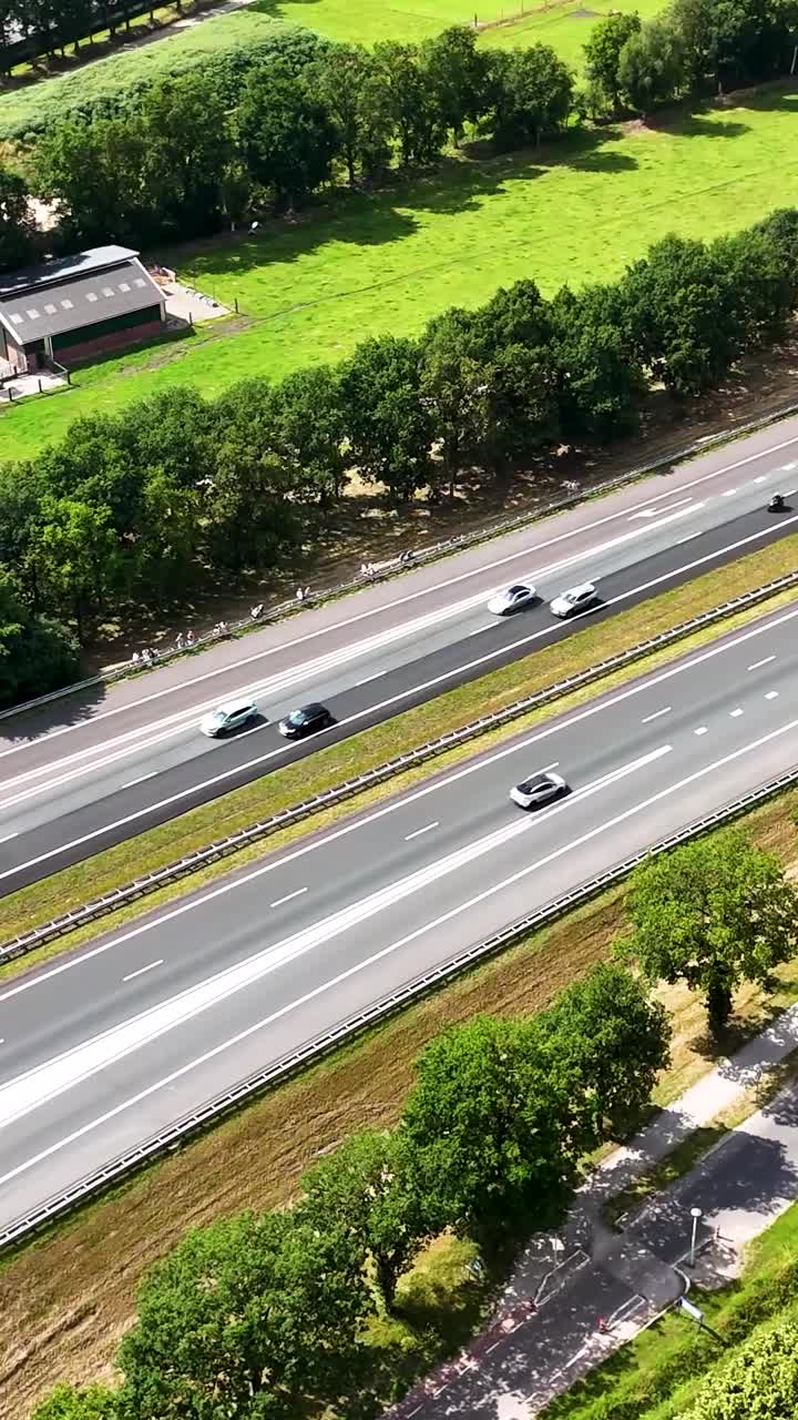 Aerial View of Highway with Cars, Small Vehicles, and Green Landscape