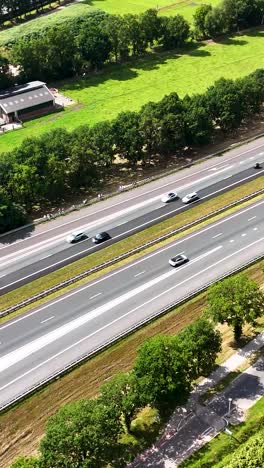 aerial view of highway with cars, small vehicles, and green landscape
