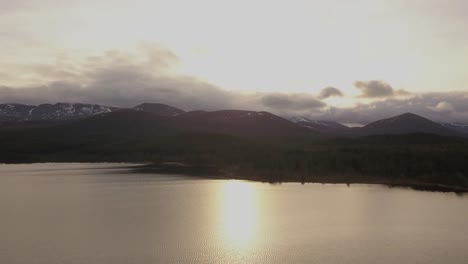 Golden-light-floods-the-scene-as-we-fly-over-a-lake-in-Scotland