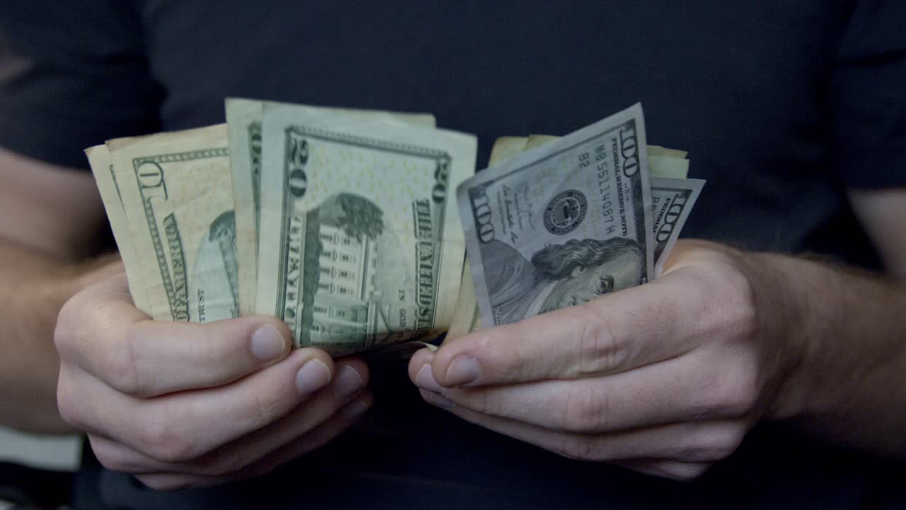 Pessoa Contando Dinheiro Americano – Mão Separando e Folheando Notas de Dólar.