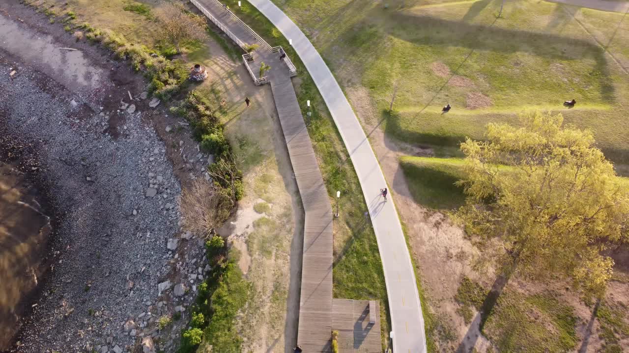 ciclista montando bicicleta al atardecer a lo largo del sendero costero, buenos aires en argentina