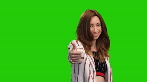 Adorable-young-woman-posing-on-green-screen-showing-heart-and-thumb-up-gestures