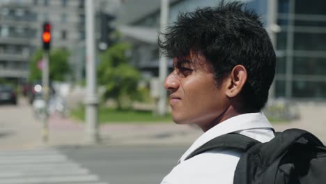 handsome indian banker waiting to go through crosswalk in city downtown