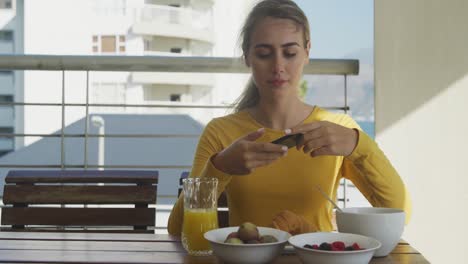 mujer tomando una foto de su comida de su teléfono inteligente