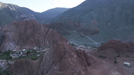 Aerial-Drone-Fly-Above-Purmamarca-Hills,-Quebrada-de-Humahuaca,-Jujuy-Argentina,-Touristic-Seven-Color-Range-Mountains,-South-America