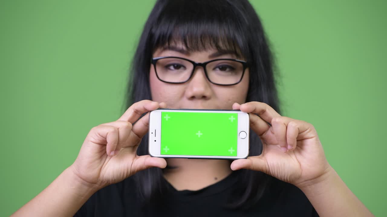 Beautiful Asian businesswoman showing phone