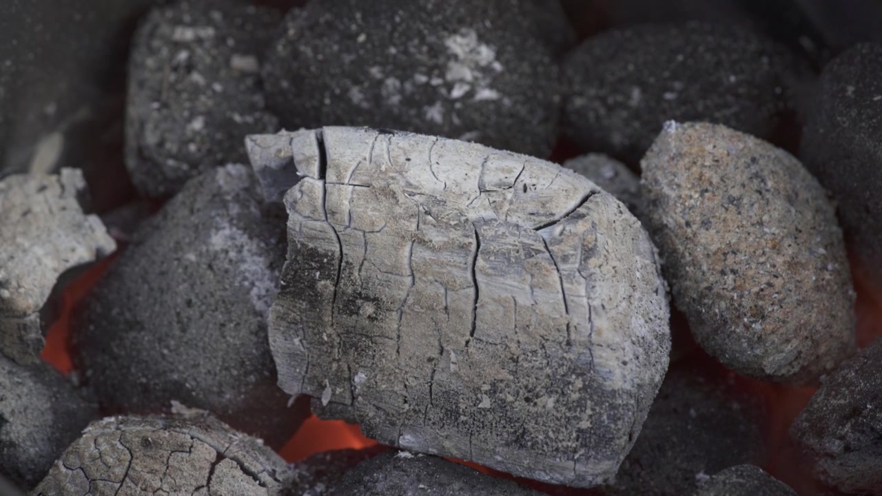 Charcoal briquettes ashing over while preheating for barbecue