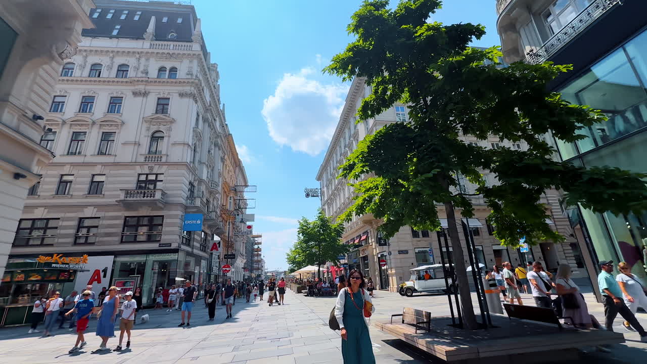 Vienna, Austria - June 9, 2025: Lots of people walk by the wide pedestrian street along the beautiful old buildings. Tour by stunning Vienna, Austria