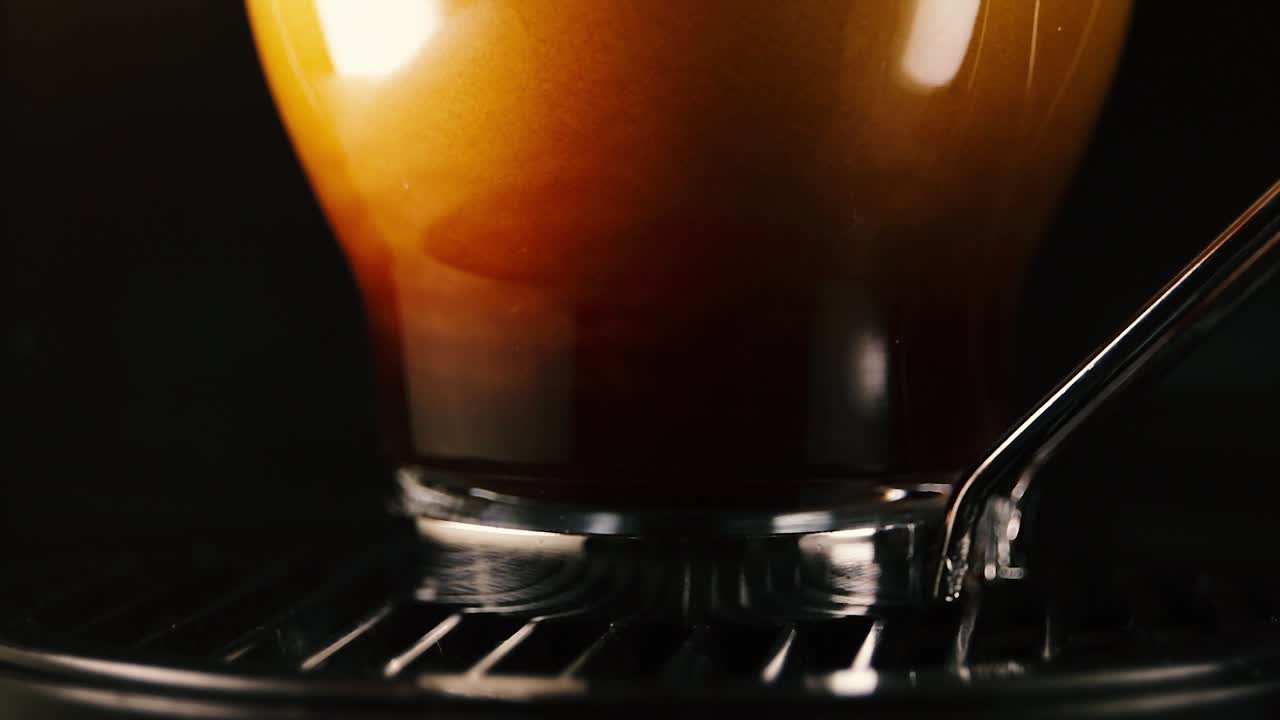 Extreme close up of pouring hot coffee into a glass cup. Lockdown