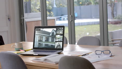 portátil en la mesa de comedor que muestra cuatro vistas de cámaras de seguridad en el hogar, cámara lenta