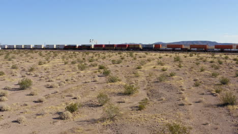 two long freight traines passing each other going in opposite directions in the desert of california