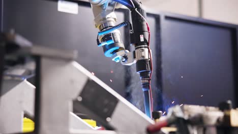 primer plano del héroe del brazo de una máquina de soldadura automatizada, durante el trabajo