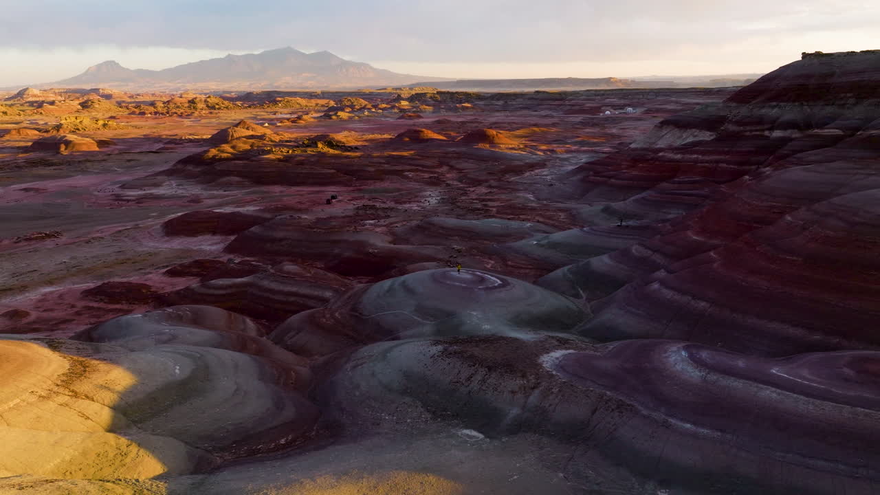chica admirando el paisaje marciano de colinas de bentonita al atardecer cerca de hanksville en utah, estados unidos