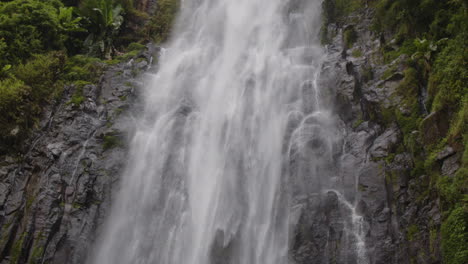 Materuni-Waterfall-cascades-down-lush-green-cliffs-in-Moshi-town,-Tanzania,-creating-a-serene-scene