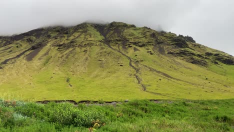 Seljavallalaug-mountain-peak-going-through-clouds-in-Iceland-landscape