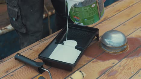 Pouring-white-primer-paint-into-roller-tray