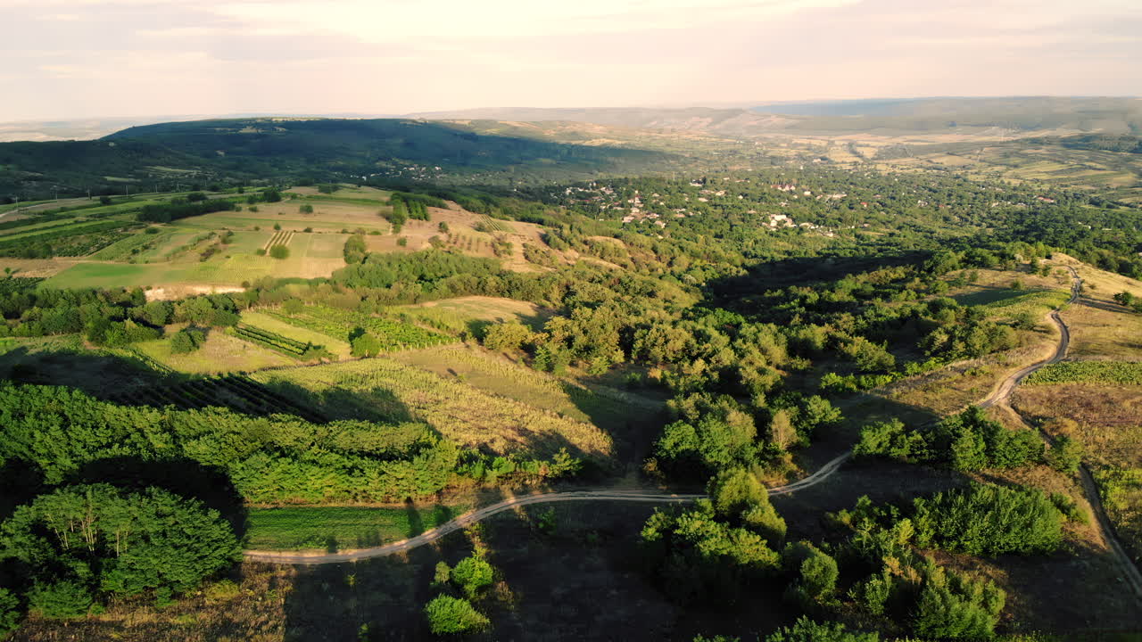 Aerial view of a lush green countryside with scattered villages and soft evening light