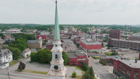 drone push in shot past church steeple revealing town of bangor, maine