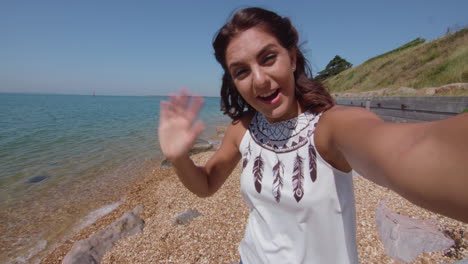 pov shot of young woman video challing a friend at the beach in slowmotion