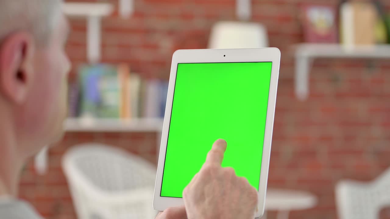 크로마 스크린 을 가진 태블릿 을 들고 있는 노인