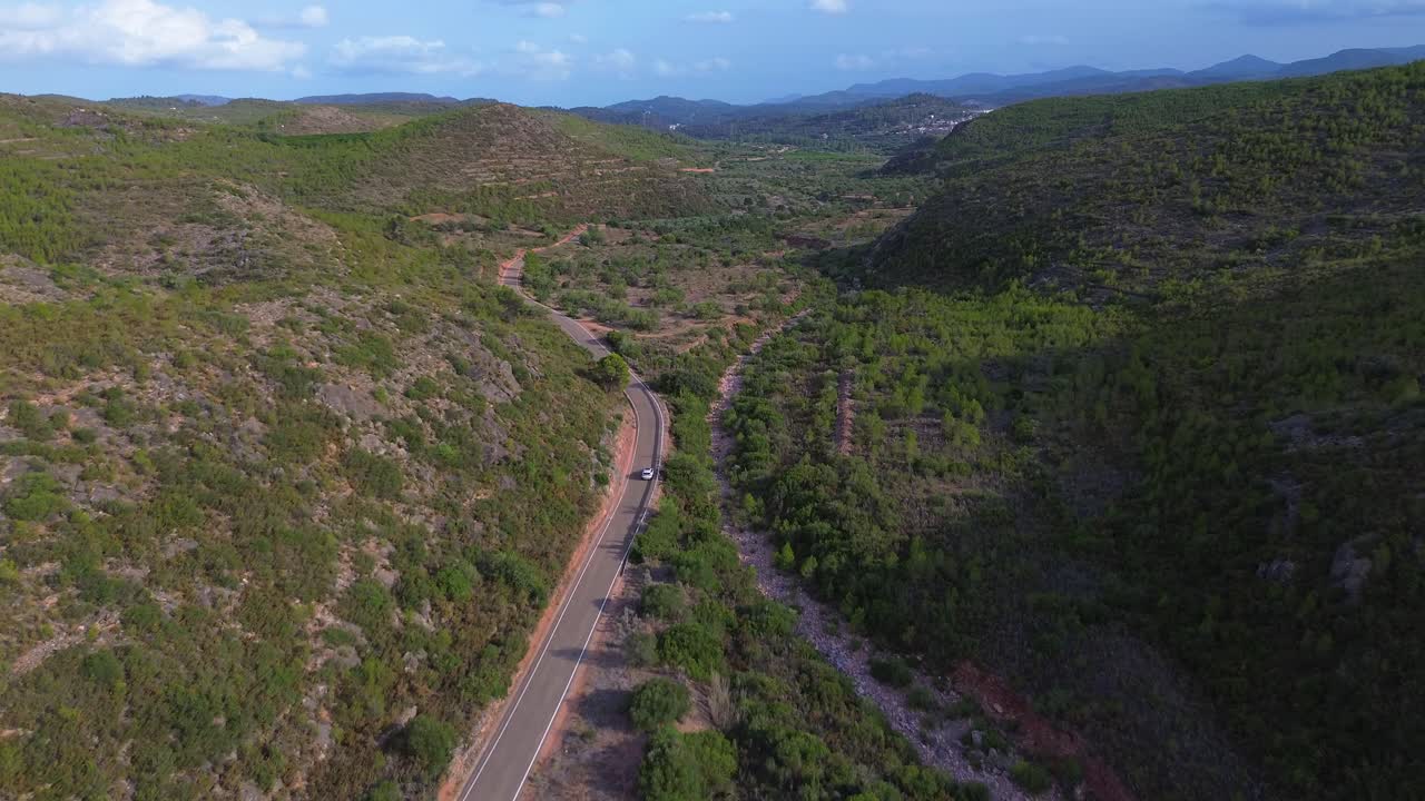 vista trasera de un automóvil que pasa por la carretera a través de las montañas en alta, comunidad valenciana, españa durante el día