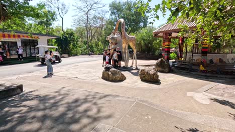 familie posiert mit einer elefantenstatue im zoo